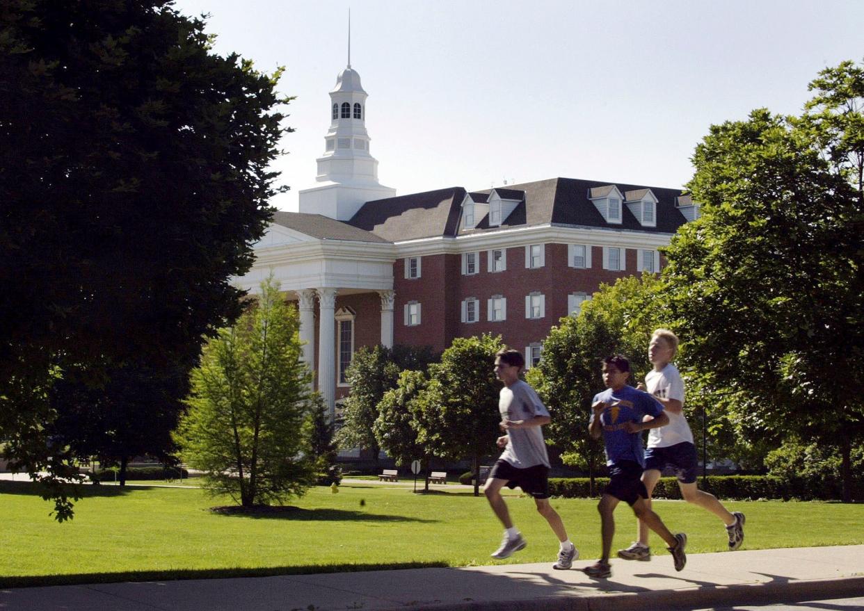 Joggers run through the campus of Wheaton College in Wheaton, Ill on June 20, 2003.