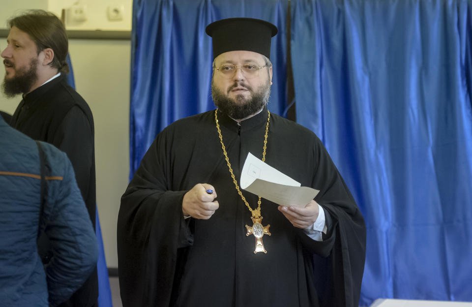 A priest exits a voting booth in Bucharest, Romania, Saturday, Oct. 6, 2018. Two days of voting on a constitutional amendment that would make it harder to legalize same-sex marriage has started in Romania. (AP Photo/Andreea Alexandru)