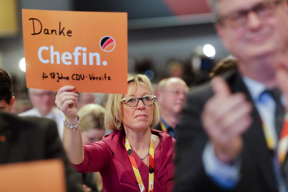 A woman shows a poster reading 'Thank you boss for 18 year's CDU chair' after the speech of Christian Democratic Union, CDU, chairwoman and German Chancellor Angela Merkel at a party convention of the Christian Democratic Party CDU in Hamburg, Germany, Friday, Dec. 7, 2018. 1001 delegates are electing a successor of German Chancellor Angela Merkel who doesn't run for party chairmanship after more than 18 years at the helm of the party. (AP Photo/Markus Schreiber)