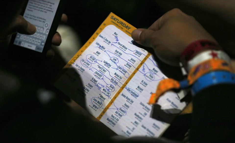 A member of the media looks at his festival program at the Coachella Valley Music and Arts Festival in Indio