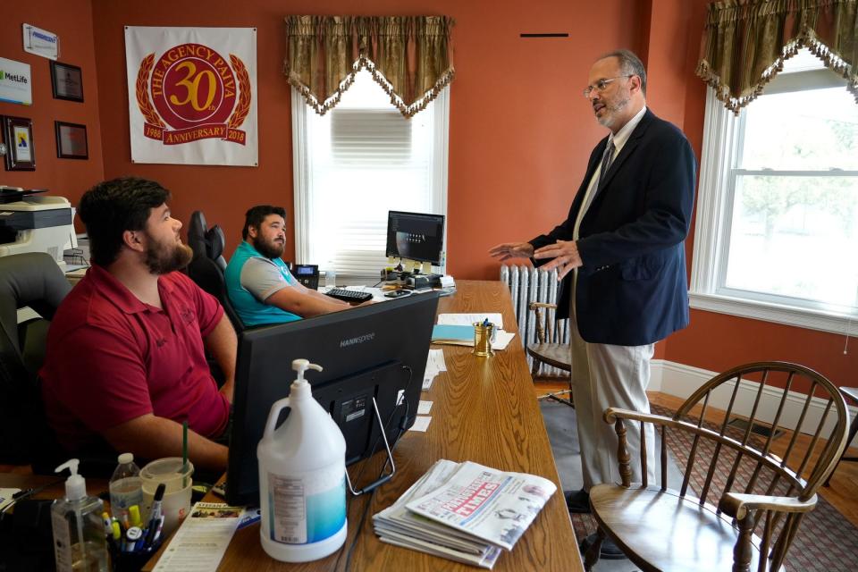 Treasurer candidate Stefan Pryor meets brothers Alex, left, and Nick Paiva at their family's insurance agency during a  business walk in East Providence on Aug 24.