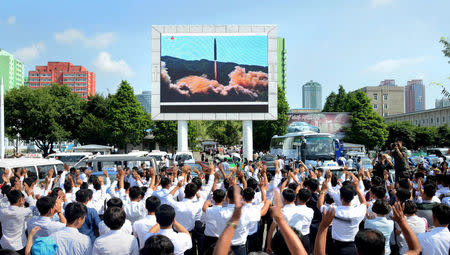 FILE PHOTO: People watch a huge screen showing the test launch of intercontinental ballistic missile Hwasong-14 in this undated photo released by North Korea's Korean Central News Agency (KCNA), July 5, 2017. KCNA/via REUTERS/File Picture