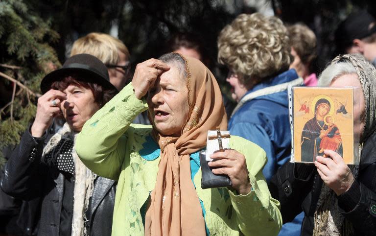 Pro-Russia supporters pray a at barricade outside the city government building seized by separatists in Mariupol