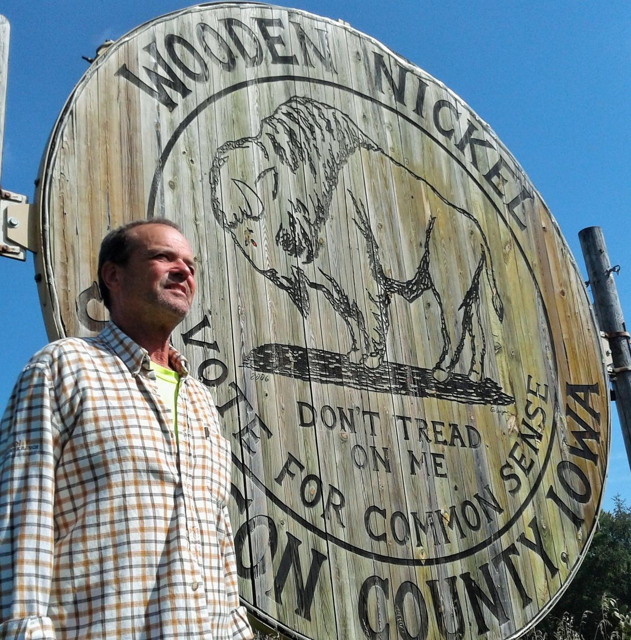 Jim Glasgow stopped to check out this sign he built in 2006 as part of a successful campaign to halt a proposed Johnson County road paving project. Now known as the World's Largest Wooden Nickel, it has become a tourist stop near I-80.