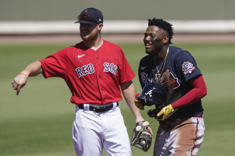 Boston Red Sox's Christian Arroyo, left, laughs with Atlanta Braves' Ronald Acuna Jr., right, in the first inning during a spring training baseball game on Monday, March 1, 2021, in Fort Myers, Fla. (AP Photo/Brynn Anderson)