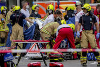 Rescue workers help an injured person after a car crashed into a crowd of people in central Berlin, Germany, Wednesday, June 8, 2022. (AP Photo/Michael Sohn)