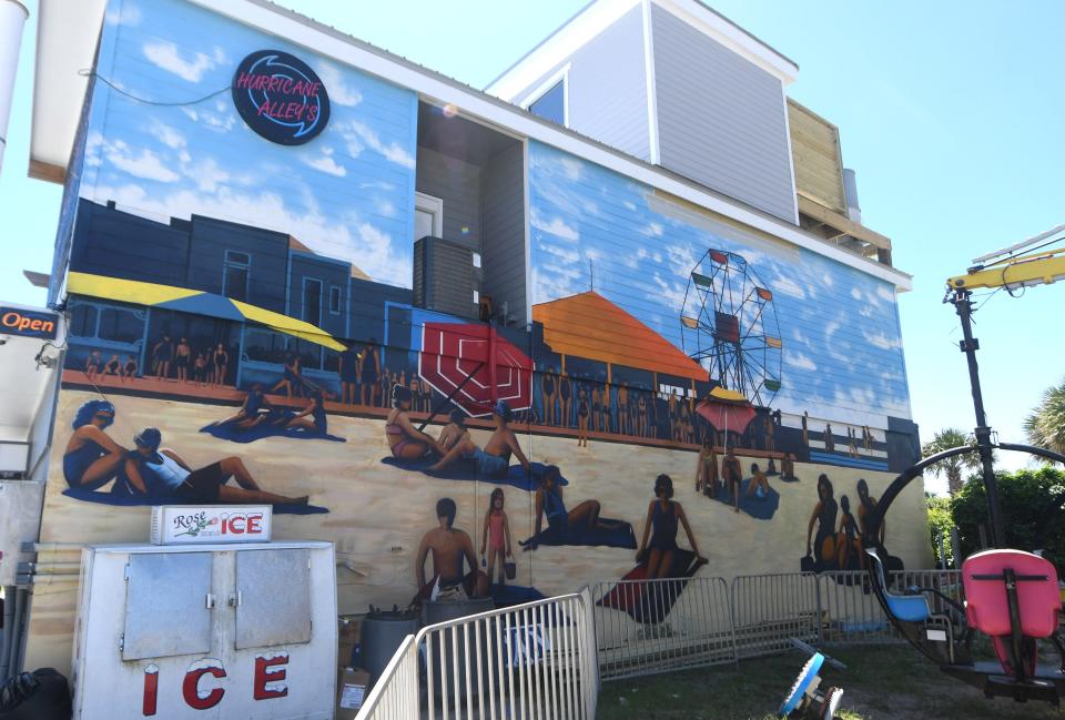 The "Summer on the Boardwalk" mural on the side of Hurricane Alley's at 5 Boardwalk is one of the numerous murals throughout Carolina Beach.     [MATT BORN/STARNEWS]