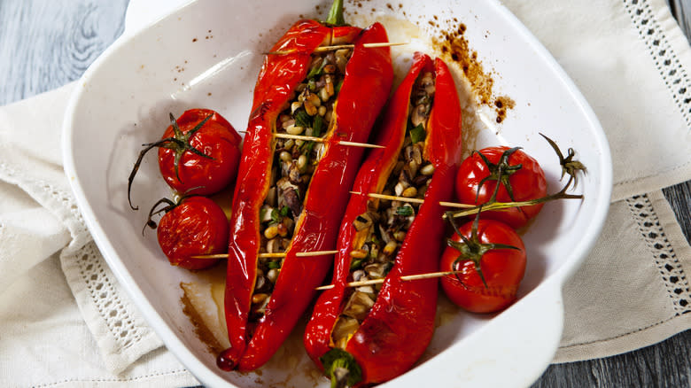 Stuffed peppers in white dish with pine nuts