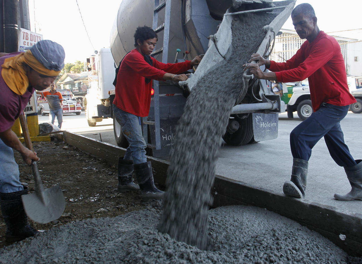 File Photo: Workers pour cement during roadworks, which are a part of the government's road rehabilitation projects, in Mandaluyong City Metro Manila November 28, 2012. REUTERS/Cheryl Ravelo