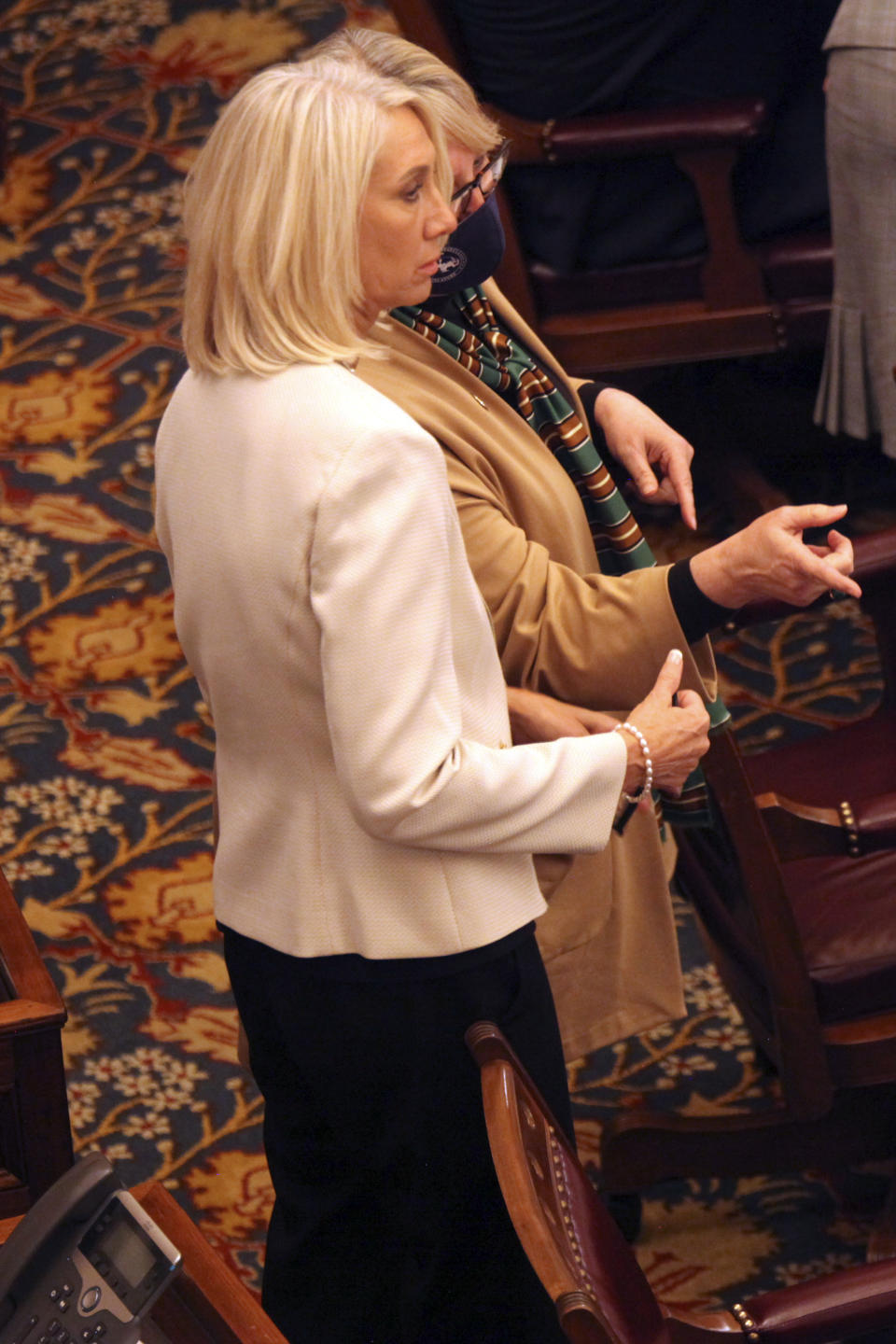 Kansas state Sens. Renee Erickson, left, R-Wichita, and Molly Baumgardner, right, R-Louisburg, confer during a debate on a bill they support on transgender athletes at the Statehouse, Wednesday, March 17, 2021, in Topeka, Kan. The bill bans transgender athletes from girls' and women's school sports. (AP Photo/John Hanna)