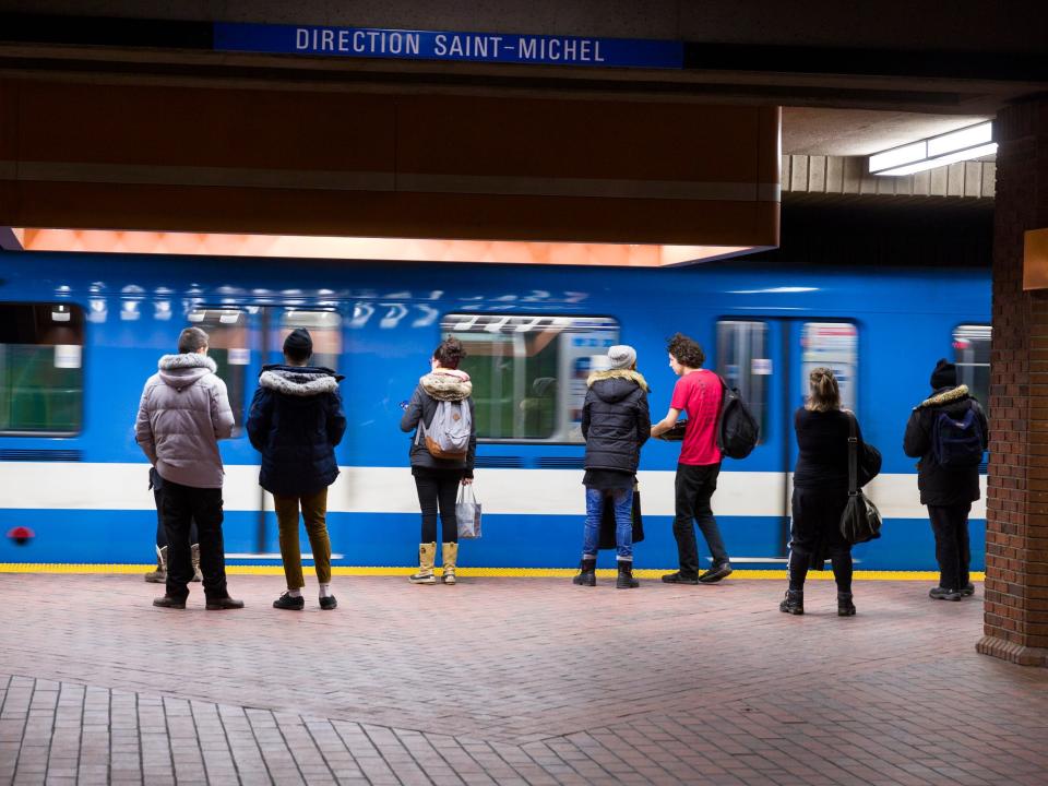 Passengers are waiting for a train in Snowdow metro station in the Montreal Metro. The Métro de Montréal is a rubber-tired, underground metro system, and the main form of public transport, in the city of Montreal.