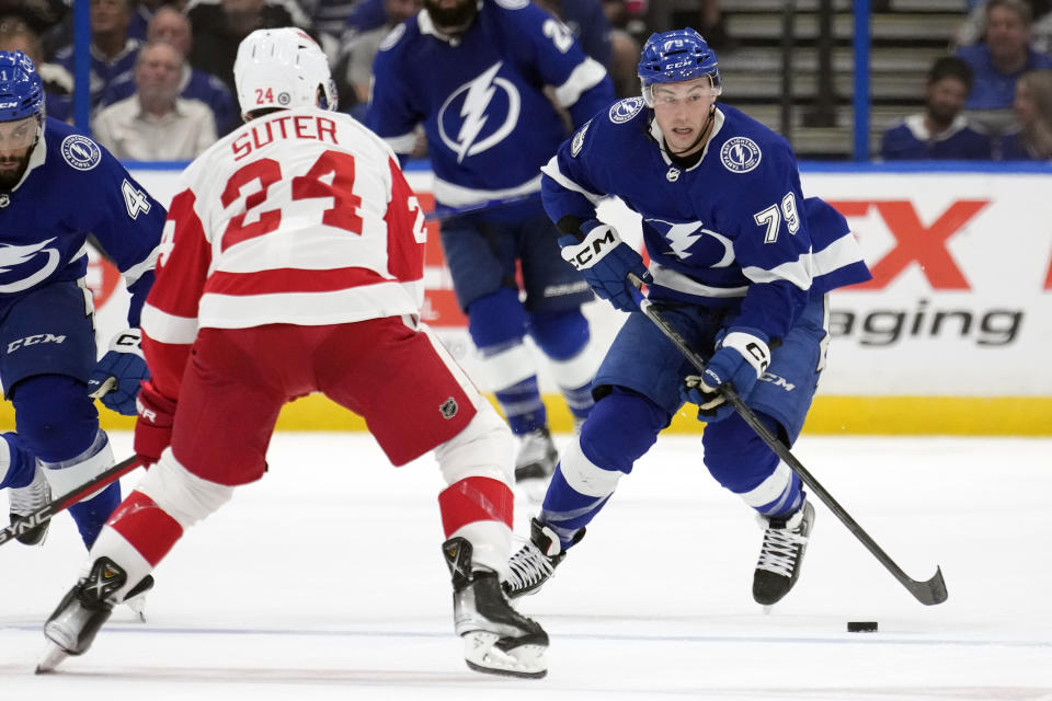 Tampa Bay Lightning center Ross Colton (79) moves the puck in front of Detroit Red Wings center Pius Suter (24) during the second period of an NHL hockey game Tuesday, Dec. 6, 2022, in Tampa, Fla. (AP Photo/Chris O'Meara)