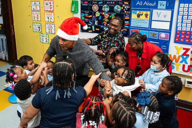 <p>The Obama Foundation</p> Parkside Academy students tug at President Barack Obama's arms during his surprise visit