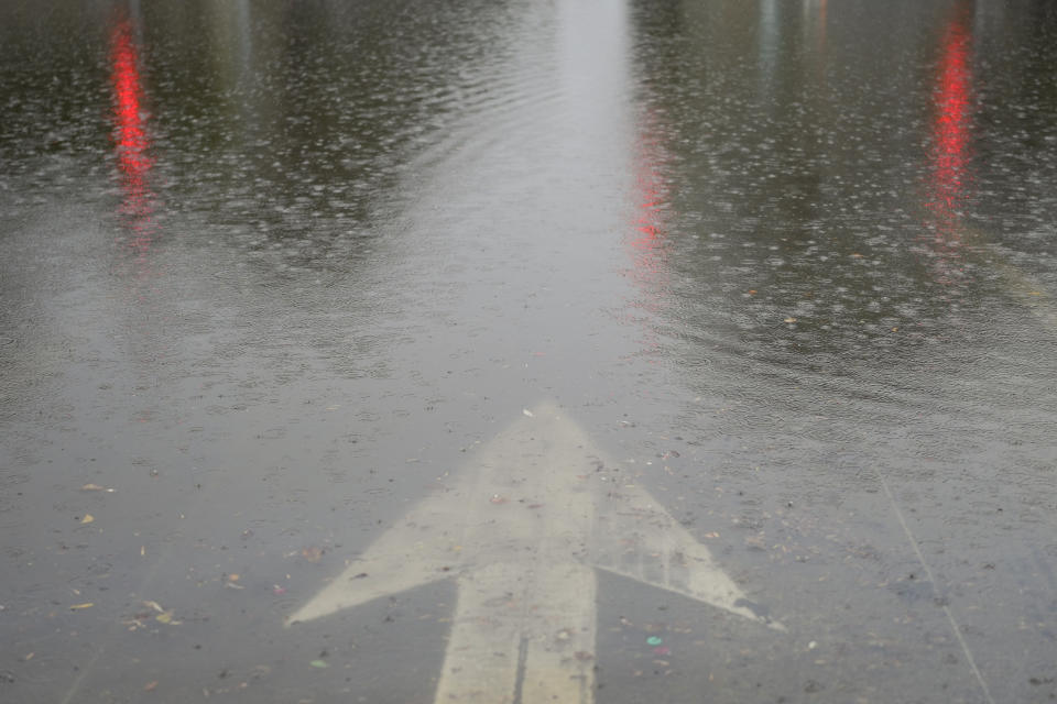 A traffic sign points to a flooded street during a rainstorm, Thursday, Dec. 21, 2023, in Santa Barbara, Calif. (AP Photo/Jae C. Hong)