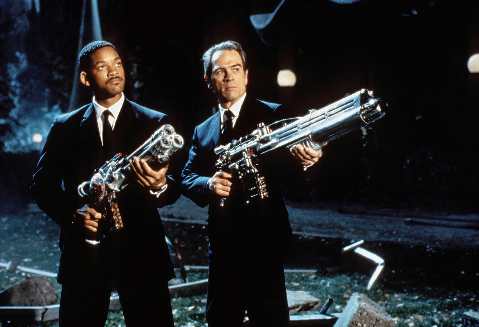 will smith and tommy lee jones holding large guns and wearing suits