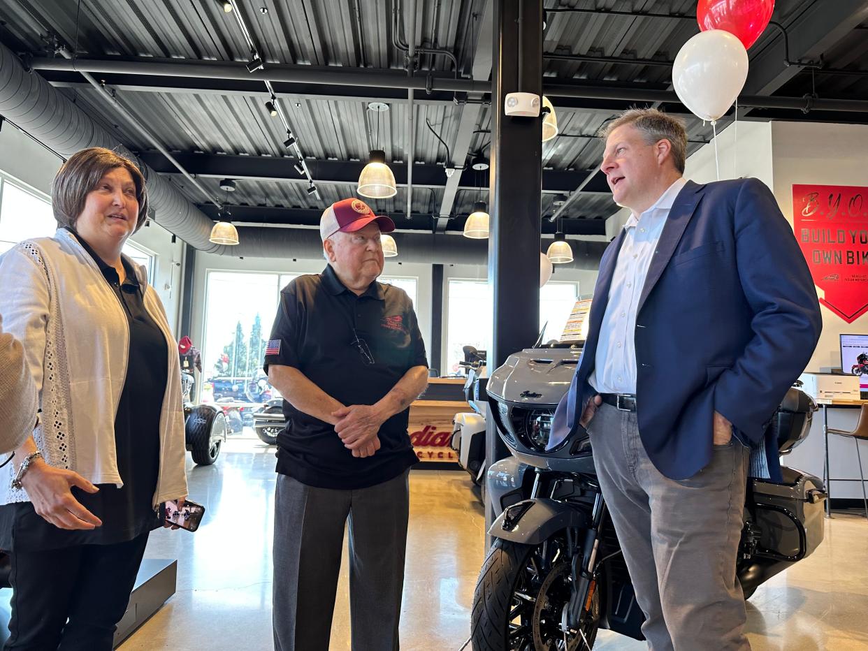 Gov. Chris Sununu (right) with Seacoast Indian Motorcycle owner Richard Nault and his wife Karen at the business' ribbon cutting Friday, April 19. Sununu told Nault the new business was a "home run."