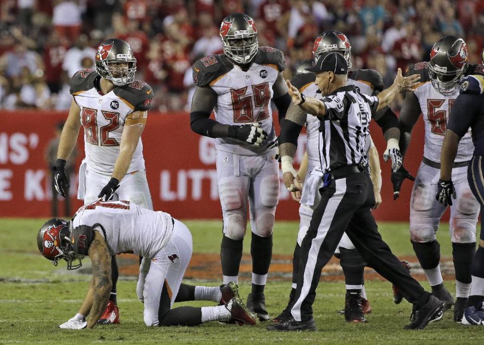Tampa Bay Buccaneers tight end Brandon Myers (82) helps wide receiver Mike Evans (13) to his feet after Evans was shaken up while making a reception during the final seconds of an NFL football game against the St. Louis Rams on Sunday, Sept. 14, 2014, in Tampa, Fla. The Rams wo 19-17. Looking on is tackle Demar Dotson (69). (AP Photo/Chris O&#39;Meara)