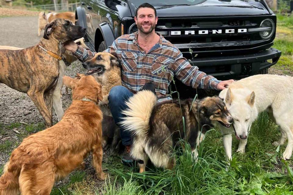 <p>The Asher House/Facebook</p> Lee Asher, owner of The Asher House animal sanctuary, poses with his dogs.