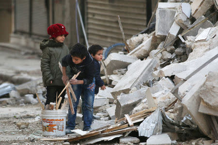 Children collect firewood amid damage and debris at a site hit yesterday by airstrikes in the rebel held al-Shaar neighbourhood of Aleppo, Syria November 17, 2016. REUTERS/Abdalrhman Ismail/File Photo