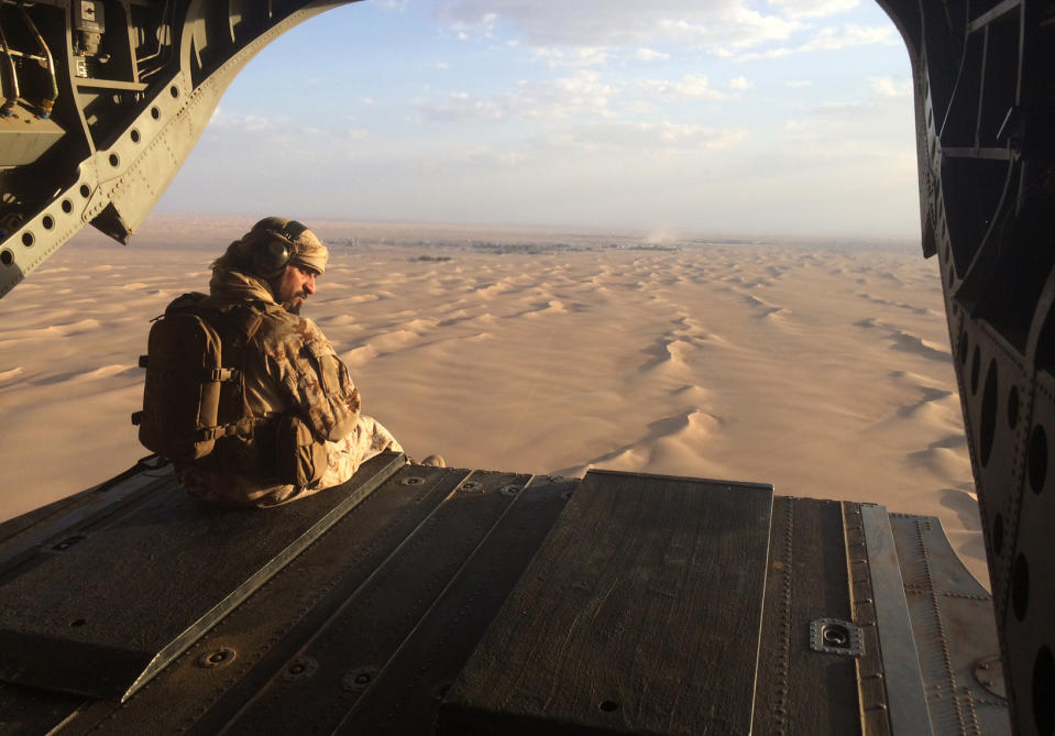 FILE - In this Sept. 17, 2015, file photo, an Emirati gunner watches for enemy fire from the rear gate of a United Arab Emirates Chinook military helicopter flying over Yemen. (AP Photo/Adam Schreck, File)