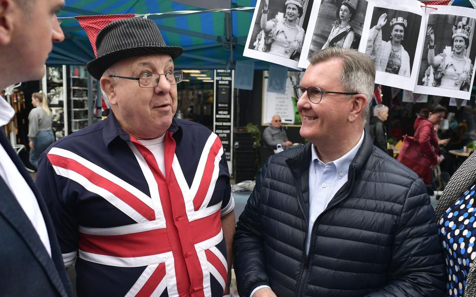 BELFAST, NORTHERN IRELAND - MAY 02: Democratic Unionist party leader Sir Jeffrey Donaldson (R) chats with a stall owner as he canvasses for votes at the Holywood May Fair on May 2, 2022 in Belfast, Northern Ireland. The province will go to the polls later this week to decide the outcome of the Northern Ireland assembly elections. - Photo by Charles McQuillan/Getty Images