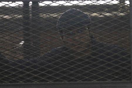 Activist Ahmed Maher stands behind bars at a court in Cairo April 7, 2014. REUTERS/Al Youm Al Saabi Newspaper