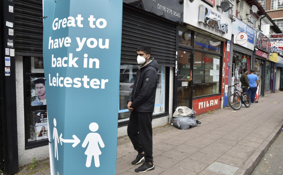 People walk past closed shops in Leicester, England, Tuesday June 30, 2020. The British government has reimposed lockdown restrictions in the English city of Leicester after a spike in coronavirus infections, including the closure of shops that don't sell essential goods and schools. (AP Photo/Rui Vieira)