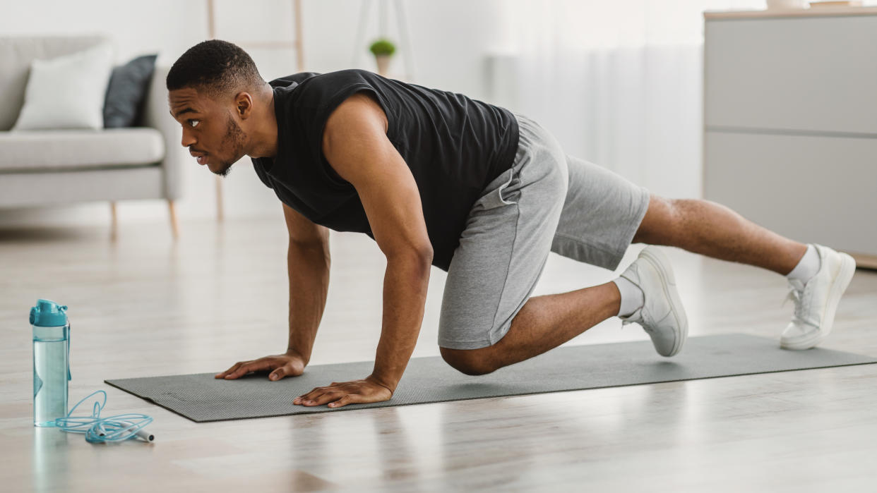  Man performing mountain climber exercises at home. 