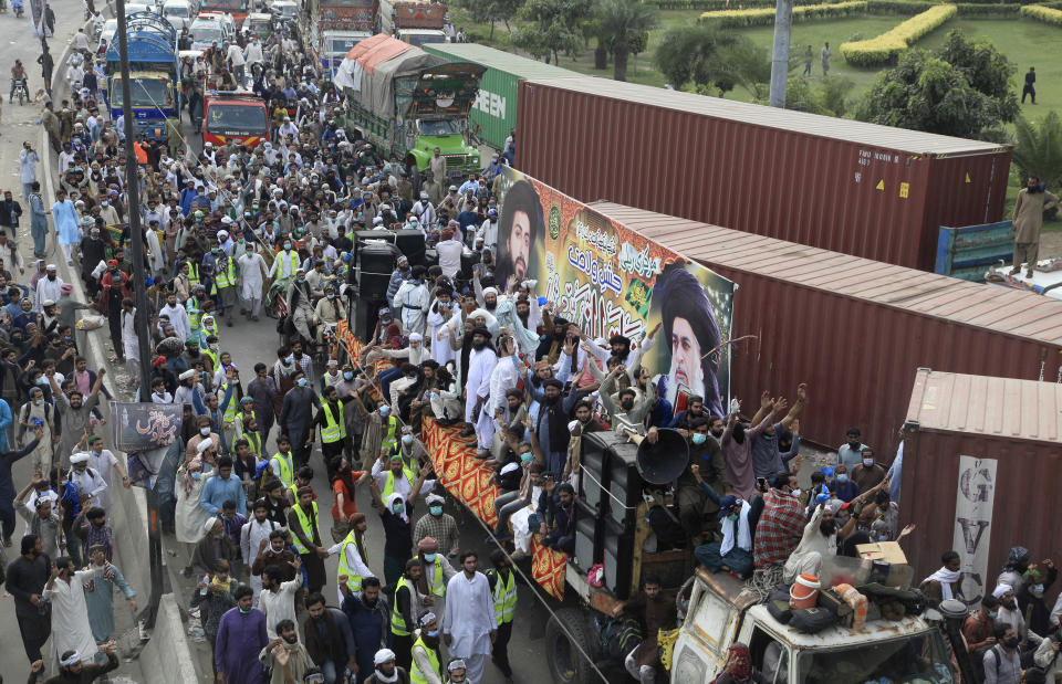 A covey of supporters of Tehreek-e-Labiak Pakistan, a banned radical Islamist party, moves toward Islamabad during a protest march, on the outskirts of Lahore, Pakistan, Saturday, Oct. 23, 2021. Thousands of supporters of the banned radical Islamist party Saturday departed the eastern Pakistan city of Lahore, clashing for a second straight day with police who lobbed tear gas into the crowd, a party spokesman and witnesses said. (AP Photo/K.M. Chaudary)