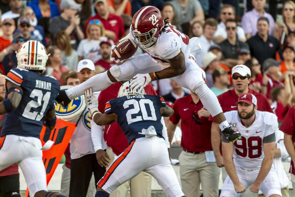 Alabama running back Najee Harris (22) hurdles Auburn defensive back Jeremiah Dinson (20) during the first half of an NCAA college football game, Saturday, Nov. 30, 2019, in Auburn, Ala. (AP Photo/Vasha Hunt)