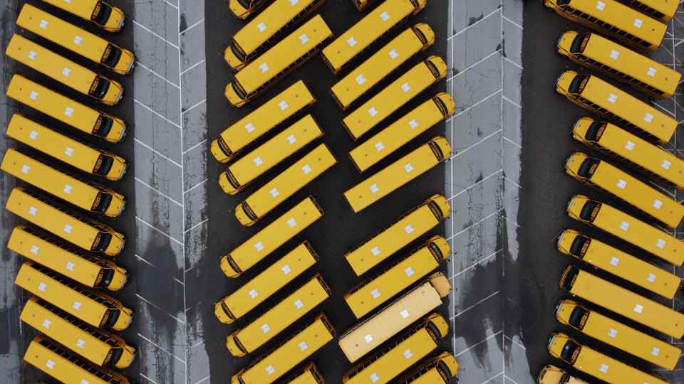 PROVIDENCE, RI, March 30 - School buses sit parked in a lot as schools remain closed due to the coronavirus. (AP Photo/David Goldman)