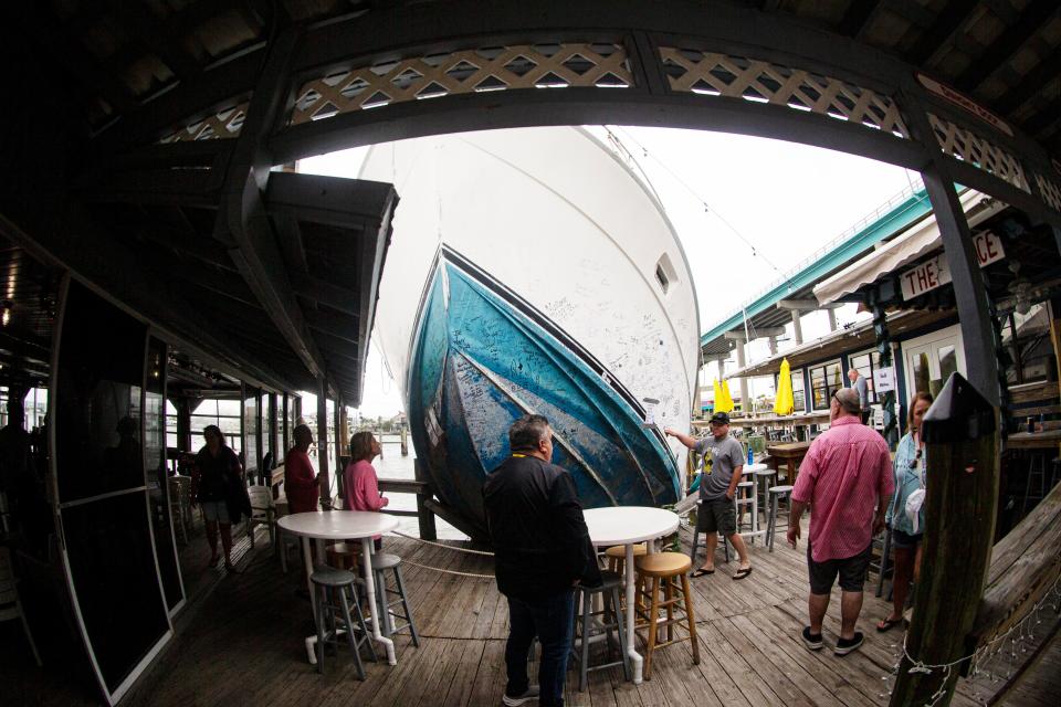 The boat that was pushed onto the dock at Bonita Bills Restaurant by Hurricane Ian on Fort Myers Beach has become a tourist attraction Thursday, Dec. 14, 2023. Patrons of the restaurant are able to sign the side of the boat. It is unknown when the boat will be removed.