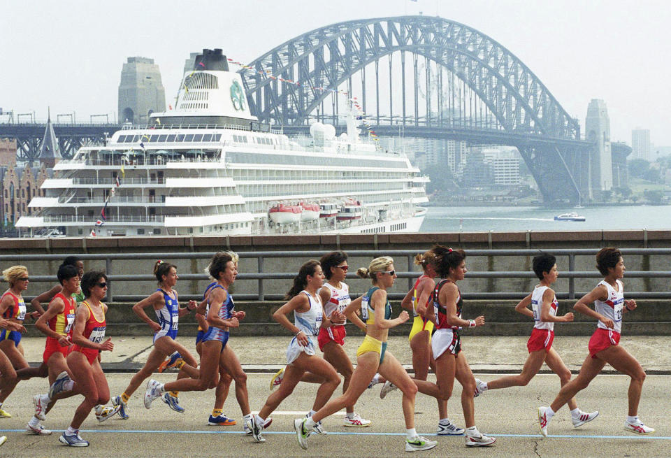 FILE - The leading pack of the women's marathon run across the Cahill expressway after crossing the Sydney Harbour Bridge in Australia, September 24, 2000. Men's world champion Tamirat Tola of Ethiopia and 2022 Paris Marathon women's champion Judith Jeptum Korir of Kenya will headline the fields for the Sydney Marathon in September 2023. (AP Photo/Clifford White, File)