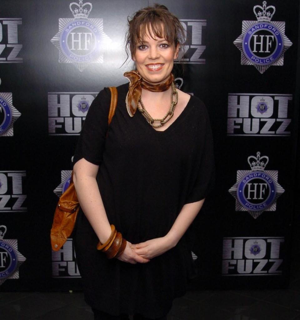 Olivia Colman at the premiere of Hot Fuzz wearing all black with leather accessories and a haircut with bangs