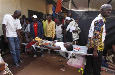 Men carry a pregnant woman on a stretcher from the Medecins Sans Frontieres clinic to a hospital in Bangui December 12, 2013. REUTERS/Emmanuel Braun