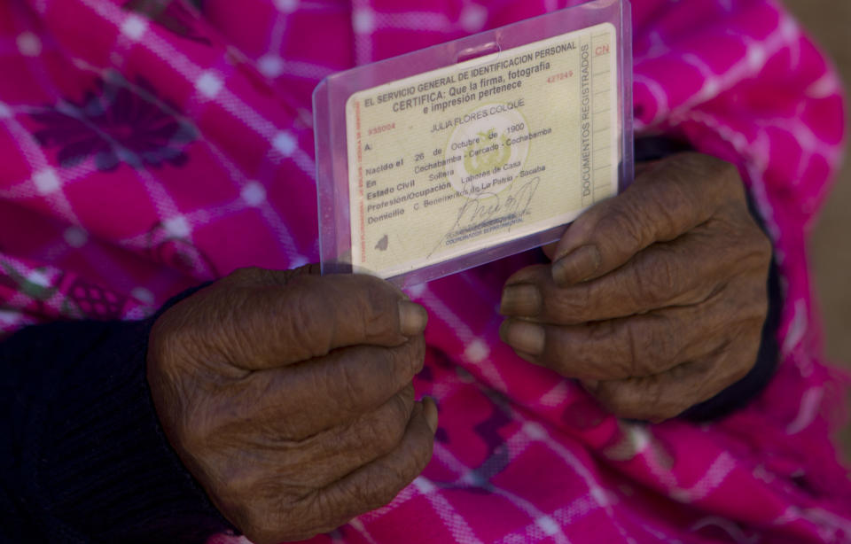 In this Aug. 23, 2018 photo, 117-year-old Julia Flores Colque holds her identification card displaying her date of birth in Sacaba, Bolivia. Birth certificates did not exist in Bolivia until 1940, and births previously were registered with baptism certificates provided by Roman Catholic priests. Flores Colque's national identity card has been certified by the Bolivian government. (AP Photo/Juan Karita)