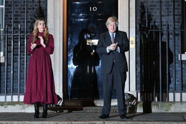 Prime Minister Boris Johnson and his partner Carrie Symonds stand outside 10 Downing Street, London, to join in with a nationwide clap in honour of Captain Sir Tom Moore, the 100-year-old charity fundraiser who died on Tuesday after testing positive for Covid-19