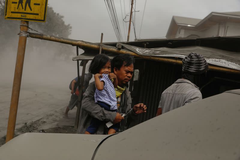 A family living near the errupting Taal Volcano evacuates in Lemery, Batangas City,