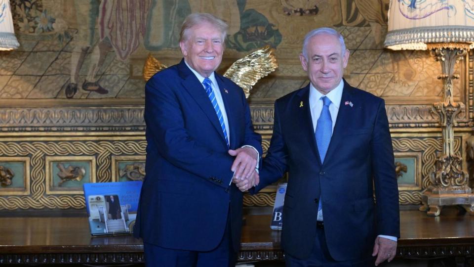 PHOTO: Former President Donald Trump shakes hands with Israeli Prime Minister Benjamin Netanyahu as they pose for a photo during their meeting at Mar-a-Lago estate, in Palm Beach, Fla., on July 26, 2024.  (Amos Ben-Gershom (GPO)/Handout via Anadolu via Getty Images)