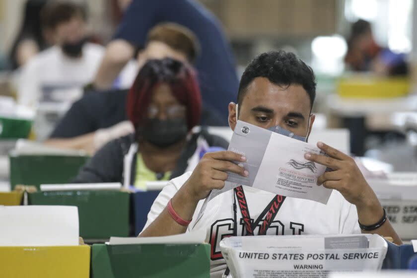 Pomona, CA - September 07: Election worker Mario Mayorga inspects a ballot that have been received for the Sept. 14, recall election at the Los Angeles County Registrar of Voters satellite office at Fairplex on Tuesday, Sept. 7, 2021 in Pomona, CA. (Irfan Khan / Los Angeles Times)