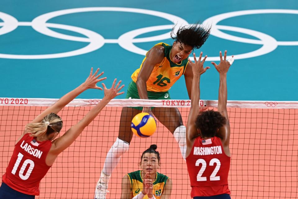 <p>Brazil's Fernanda Rodrigues (C) spikes the ball as USA's Jordan Larson (L) and USA's Haleigh Washington (R) attempt to block in the women's gold medal volleyball match between Brazil and USA during the Tokyo 2020 Olympic Games at Ariake Arena in Tokyo on August 8, 2021. (Photo by JUNG Yeon-je / AFP) </p> 