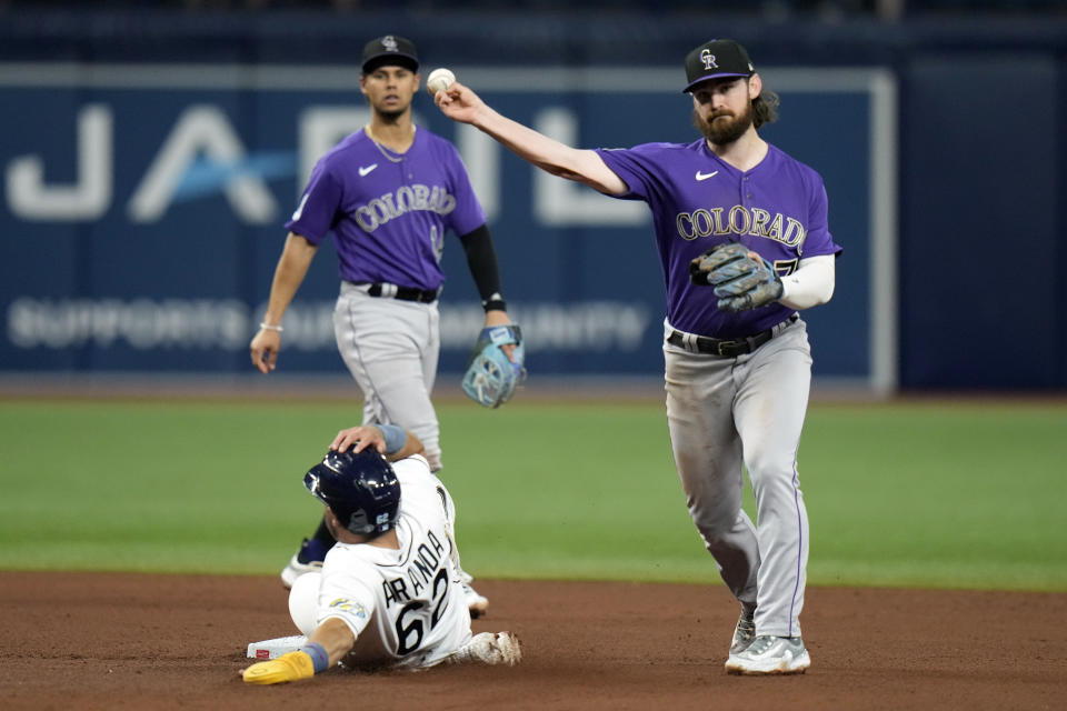 Colorado Rockies second baseman Brendan Rodgers (7) forces Tampa Bay Rays' Jonathan Aranda (62) at second base and relays the throw to first base in time to turn double play on Yandy Diaz during the seventh inning of a baseball game Wednesday, Aug. 23, 2023, in St. Petersburg, Fla. (AP Photo/Chris O'Meara)