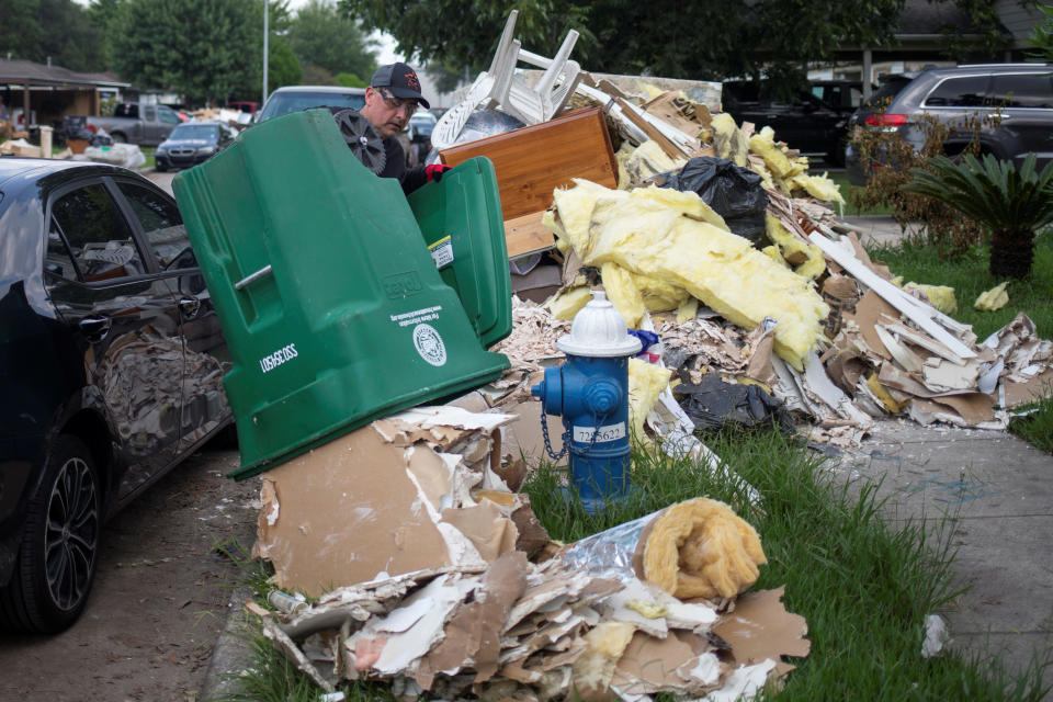 A man disposes of drywall while salvaging through belongings from his home on Sept. 2.