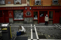 A man stands outside of a pharmacy wearing face protection during confinement to prevent the spread of coronavirus COVID-19, in Pamplona, northern Spain, Wednesday, April 8, 2020. COVID-19 causes mild or moderate symptoms for most people, but for some, especially older adults and people with existing health problems, it can cause more severe illness or death. (AP Photo/Alvaro Barrientos)