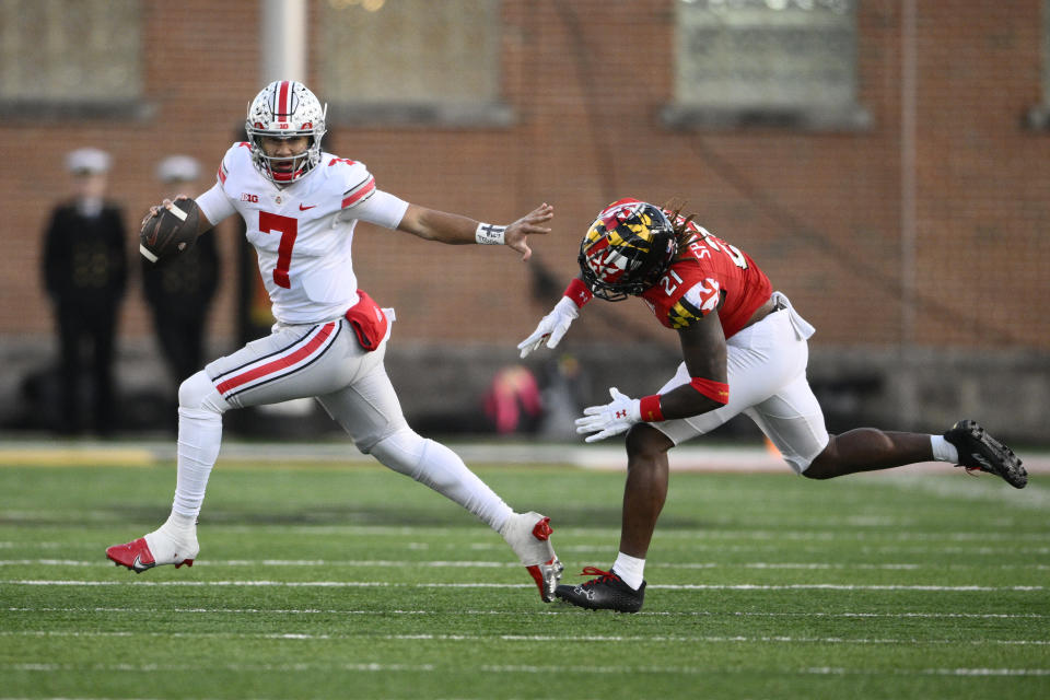 Ohio State quarterback C.J. Stroud (7) scrambles past Maryland linebacker Gereme Spraggins during the first half of an NCAA college football game, Saturday, Nov. 19, 2022, in College Park, Md. (AP Photo/Nick Wass)