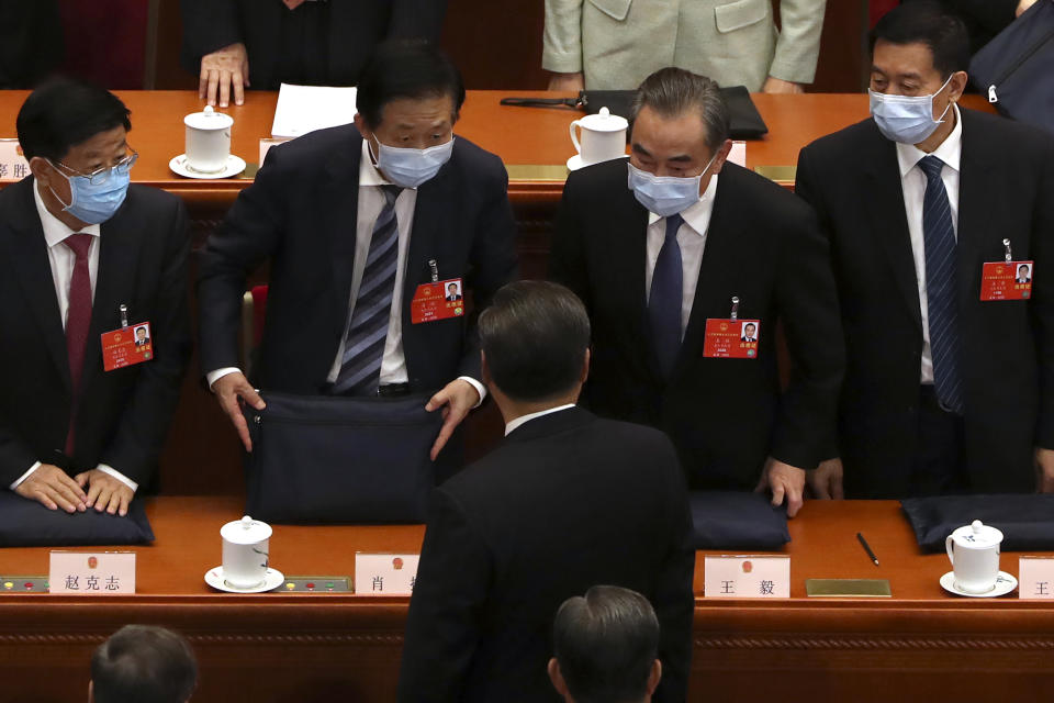 Chinese Foreign Minister Wang Yi, second from right, talks with Chinese President Xi Jinping, center, after the opening session of China's National People's Congress (NPC) at the Great Hall of the People in Beijing, Friday, May 22, 2020. (AP Photo/Ng Han Guan, Pool)