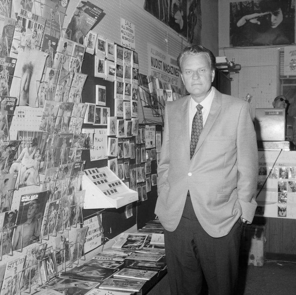 Graham looks at some racy magazines and books in a bookstore during a stroll through New York's Times Square. "Anyone walking down Times Square can see why New York is in need of a great spiritual and moral awakening," he said.