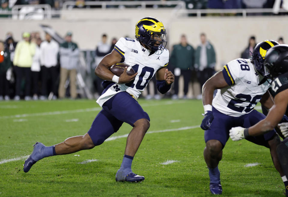 FILE - Michigan quarterback Alex Orji runs during the team's NCAA college football game against Michigan State, Oct. 21, 2023, in East Lansing, Mich. Michigan coach Sherrone Moore will have a lot of decisions to make in his first season, leading the defending national champions after Jim Harbaugh bolted to coach the Los Angeles Chargers. Whom he chooses to start at quarterback will be potentially pivotal. Moore has a lot of options, including the speedy Orji and experienced Jack Tuttle. (AP Photo/Al Goldis, File)