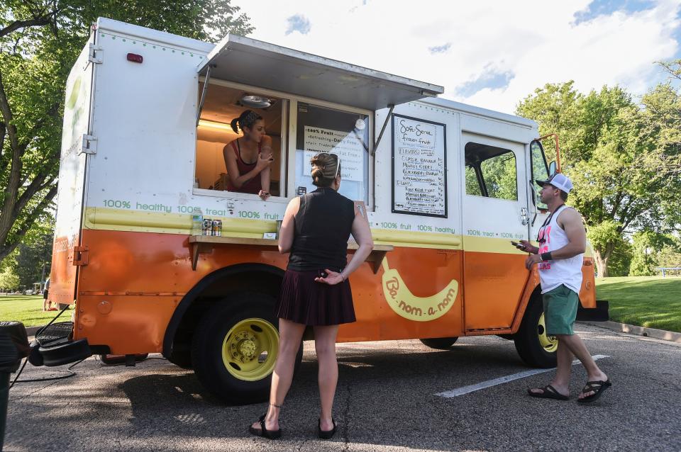 Amanda Jones speaks with customers from the Ba-nom-a-nom truck June 2, 2015, in City Park in Fort Collins.