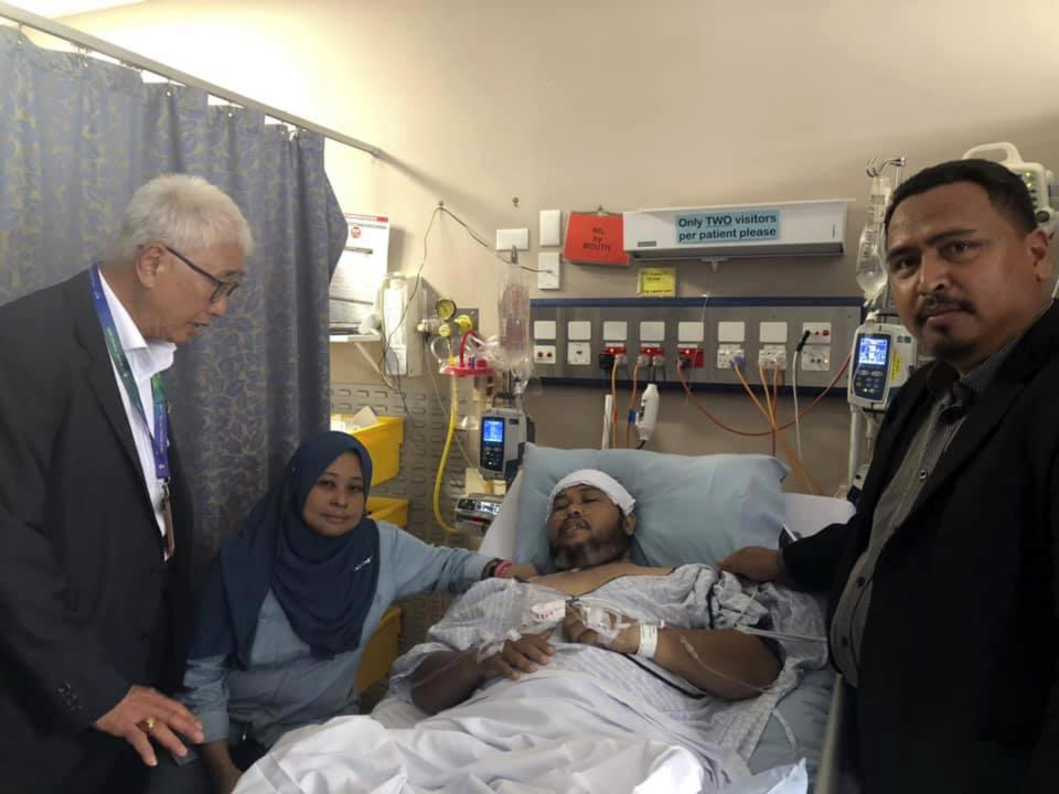 In this photo provided by Azrul Mahathir Aziz, Phee Boon Poh, left, chairman of the state caring society and welfare committee, Zurina Mohi, second from left, wife of Malaysian victim Mohamad Tarmizi Shui, third from left, and Azrul Mahathir Aziz, right, representative of the Penang state government visit Tarmizi who receives medical treatment at Christchurch Hospital in Christchurch, New Zealand, Sunday, March 17, 2019. (Azrul Mahathir Aziz via AP)